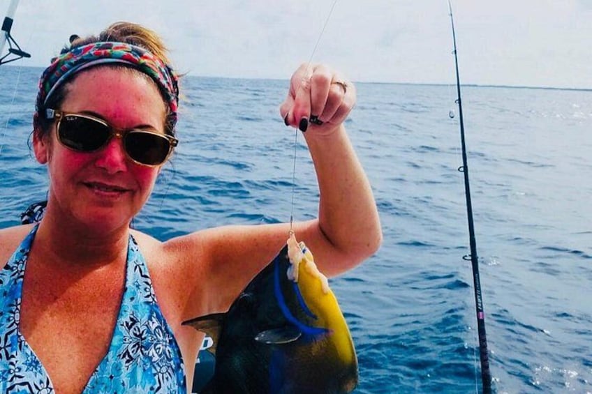 A person holding a fish on a boat. 3