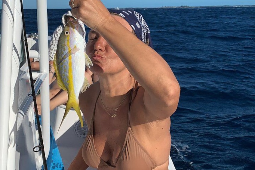A person holding a fish on a boat with the ocean in the background. 2