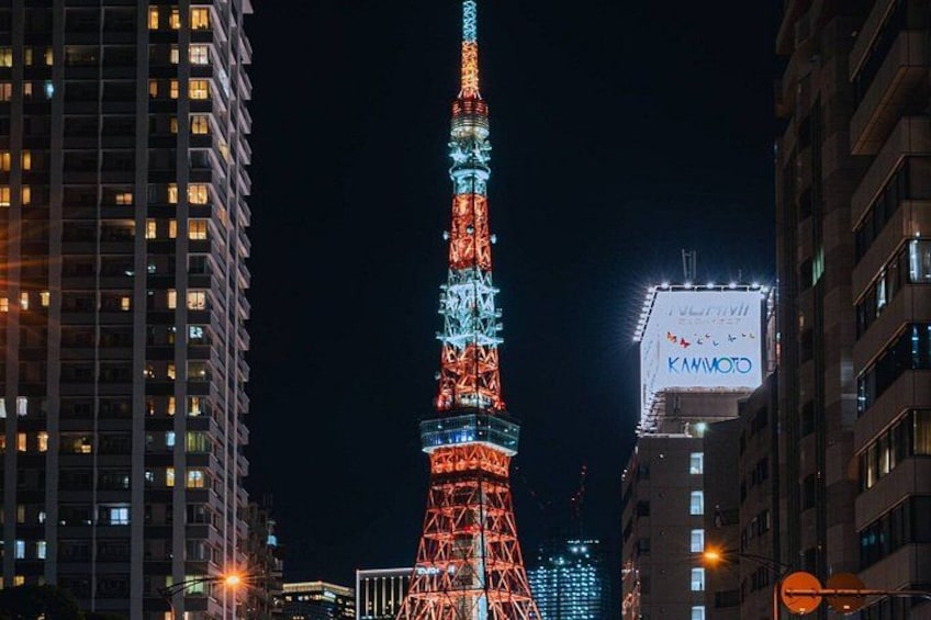A brightly lit tower with a blue and red color scheme, surrounded by modern buildings. 4