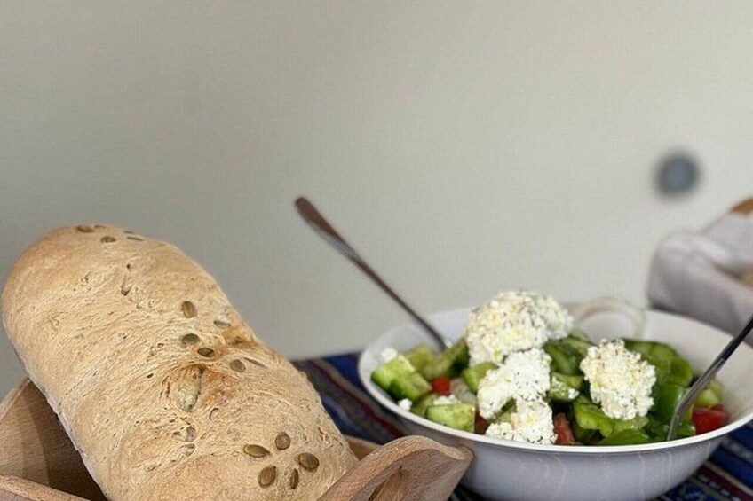 A loaf of bread and a bowl of salad with feta cheese. 2