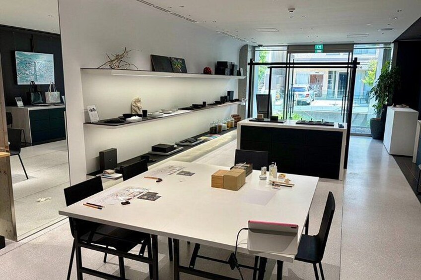 A modern office space with a long table, chairs, and shelves with decorative items. 1