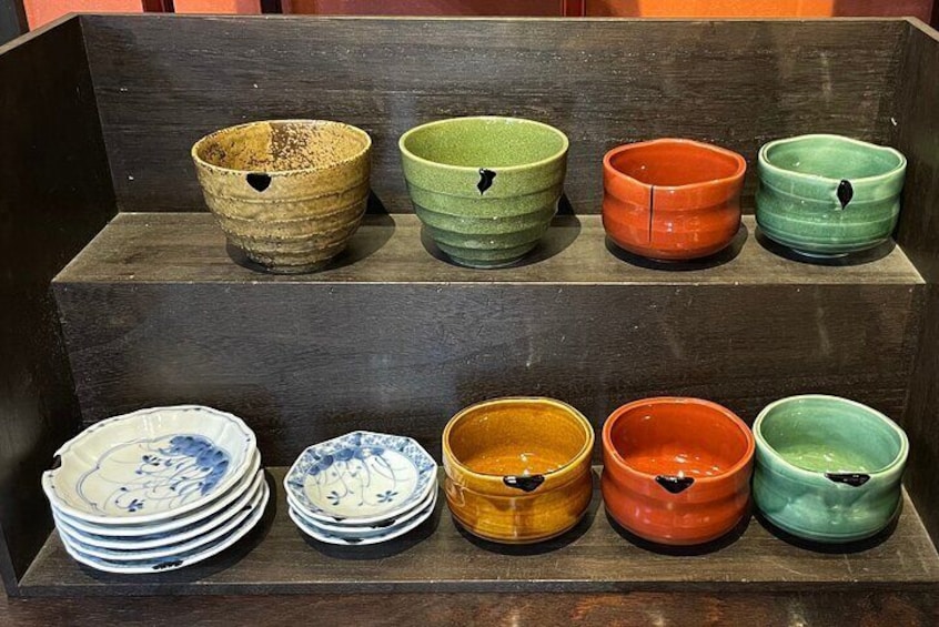 A display of ceramic bowls and plates with various colors and designs. 3