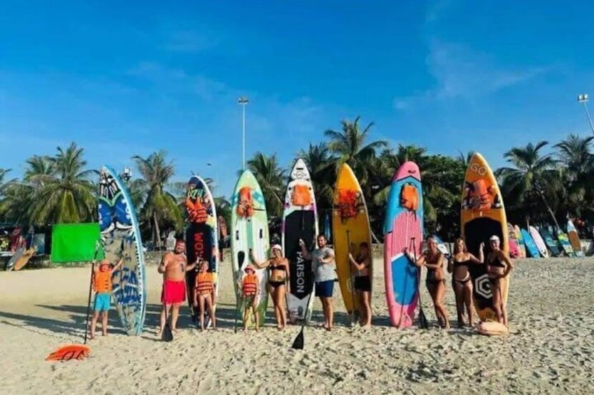 A group of people on a beach holding surfboards. 5