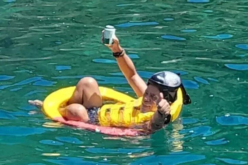 A person floating on a yellow inner tube in water. 4