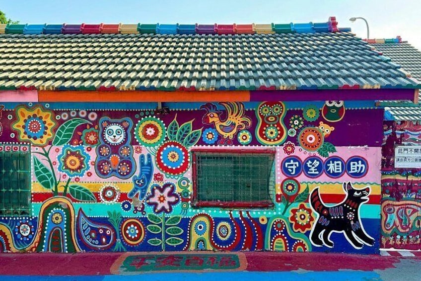 A colorful building with a tiled roof and vibrant murals. 4