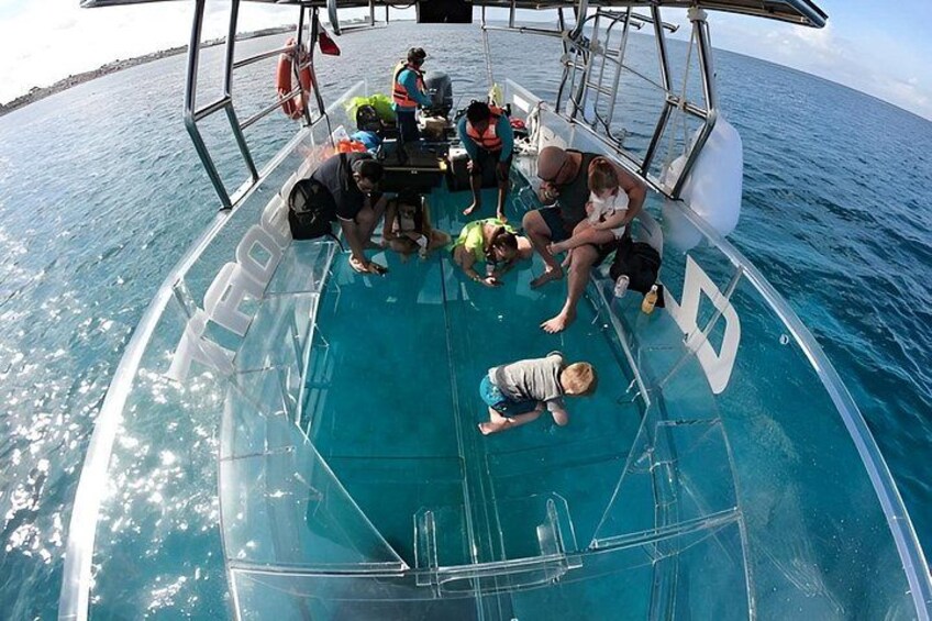 A group of people on a boat with a clear blue sea in the background. 5