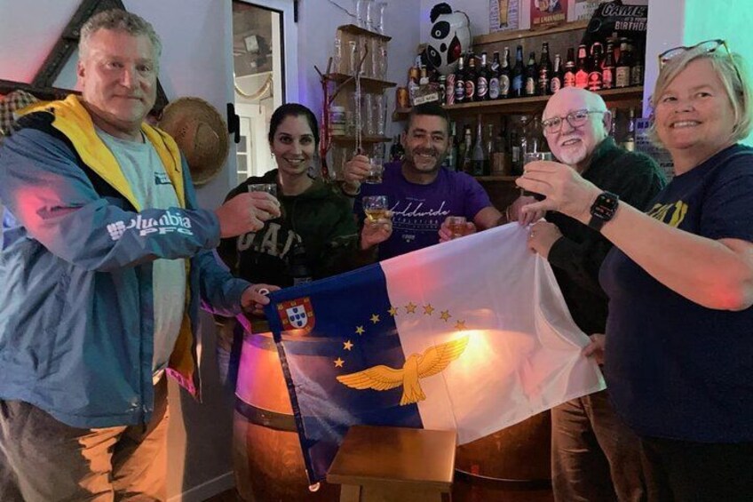 A group of people holding a flag with a coat of arms and stars. 4