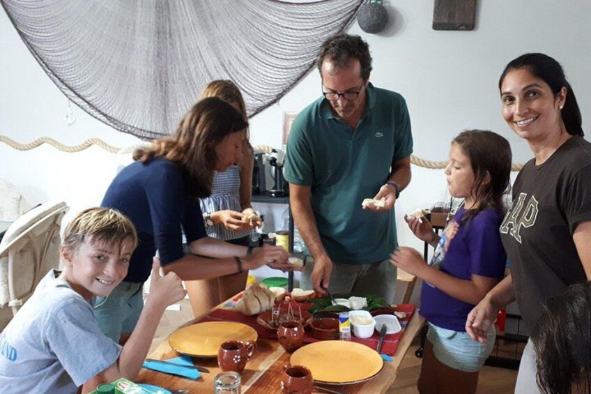 Una familia comiendo en una mesa con comida y bebidas. 1