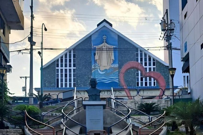A building with a mural, a statue, and a heart-shaped structure in front. 1
