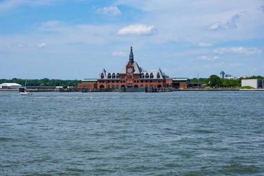 A historic building with a clock tower by a body of water. 3