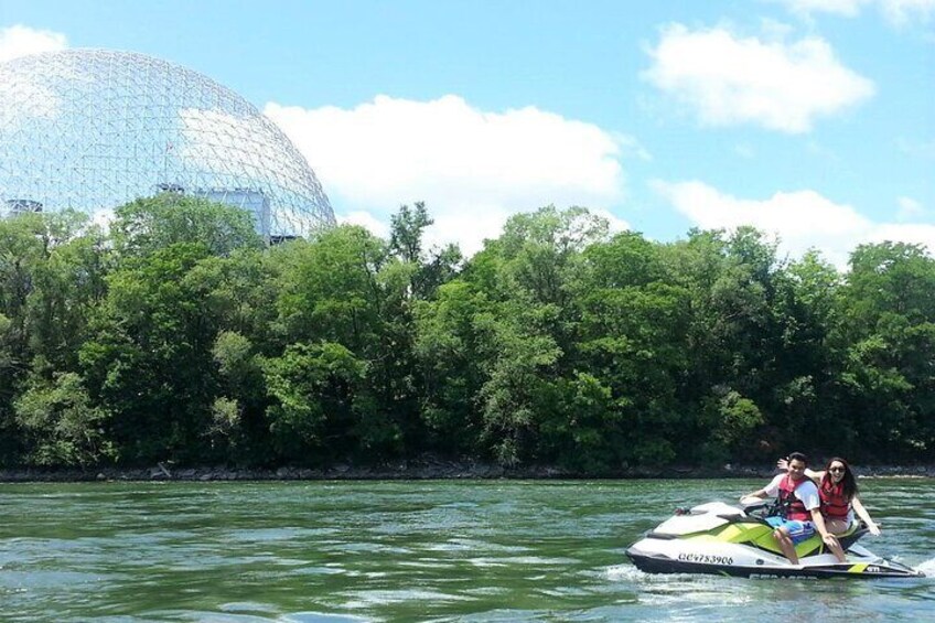 A water jet ski on a river with a large dome-shaped building in the background. 3