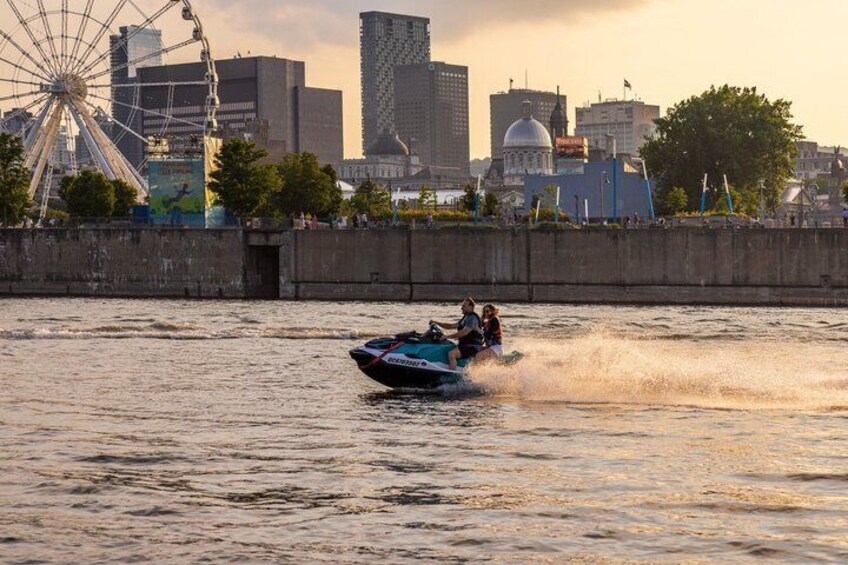 A jet ski on a river with a city skyline in the background. 1