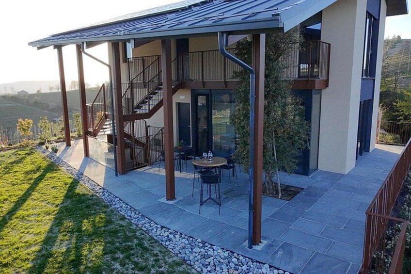 A modern house with a covered patio, outdoor furniture, and a view of the countryside. 4