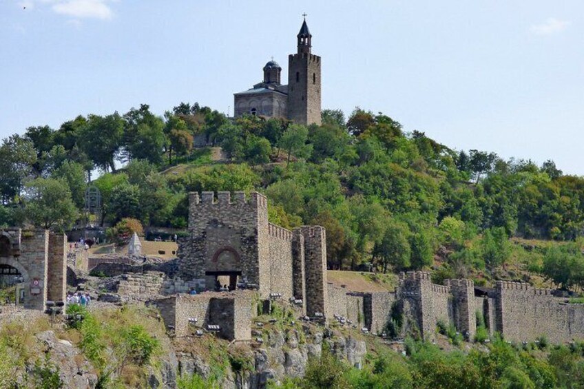 A historic castle on a hill with ruins and a church. 1