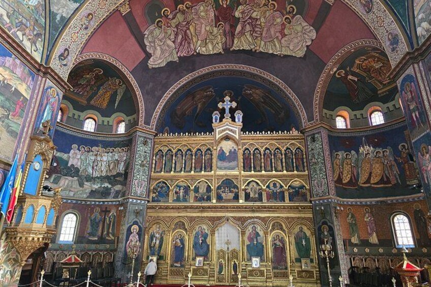 A richly decorated interior with ornate ceilings, religious iconography, and a central altar. 4