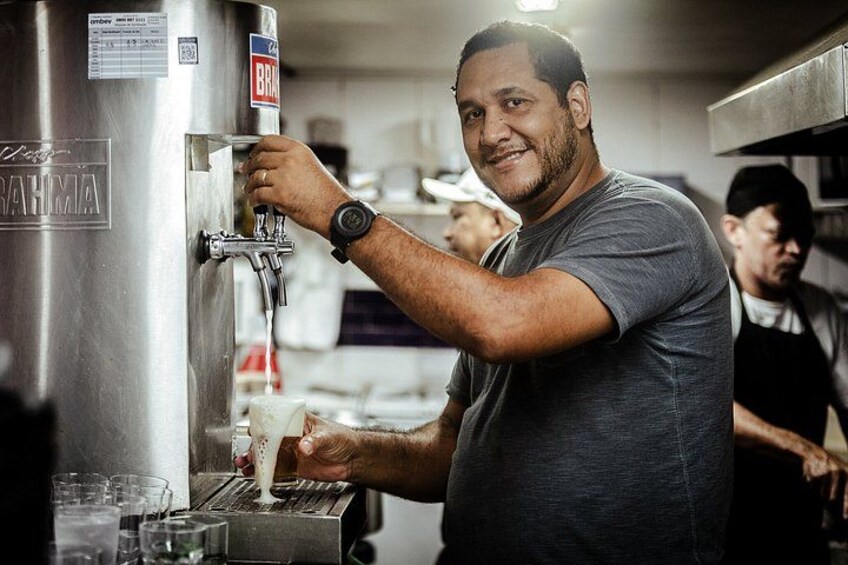 A person operating a beer tap in a commercial setting. 5