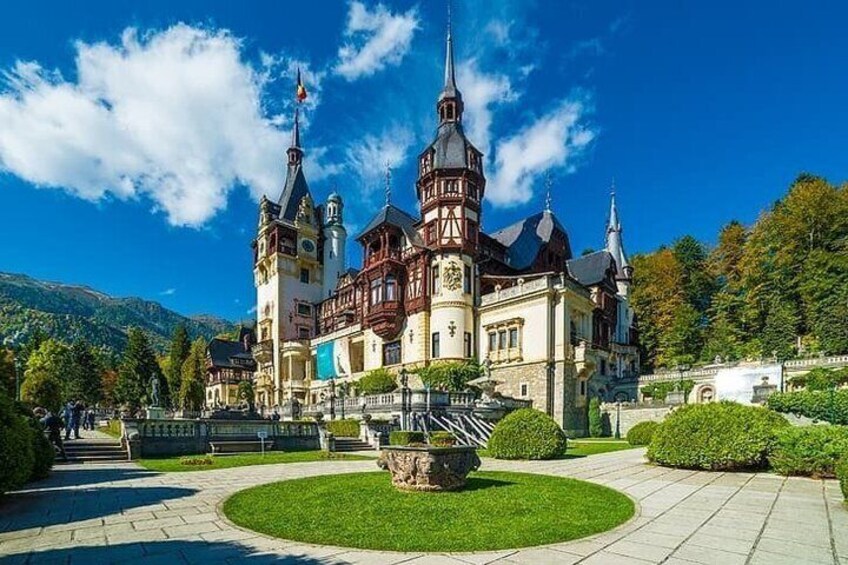 A historic building with multiple towers and a well-maintained garden. 2