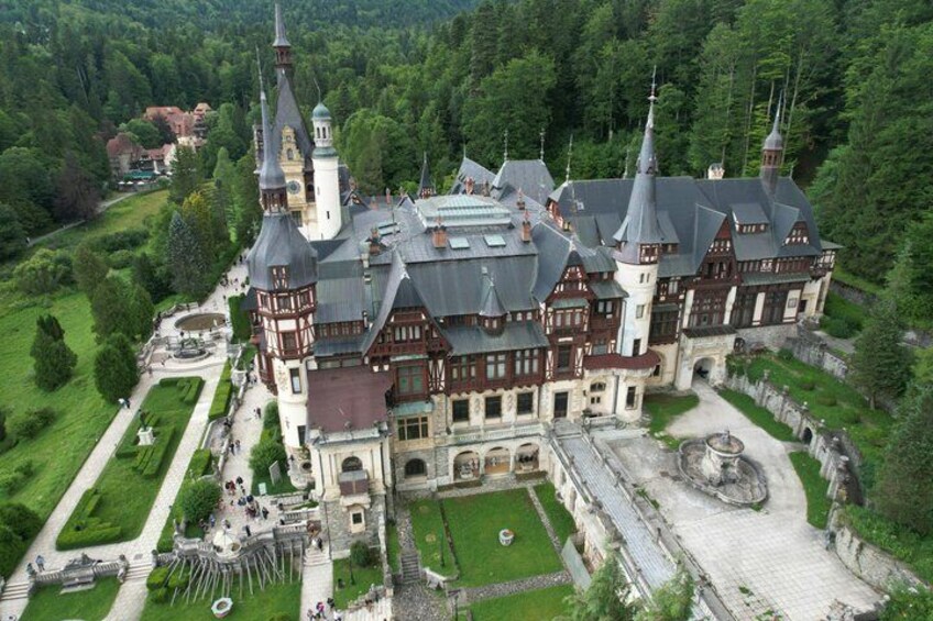 A large, historic building with multiple towers and a well-maintained garden. 4