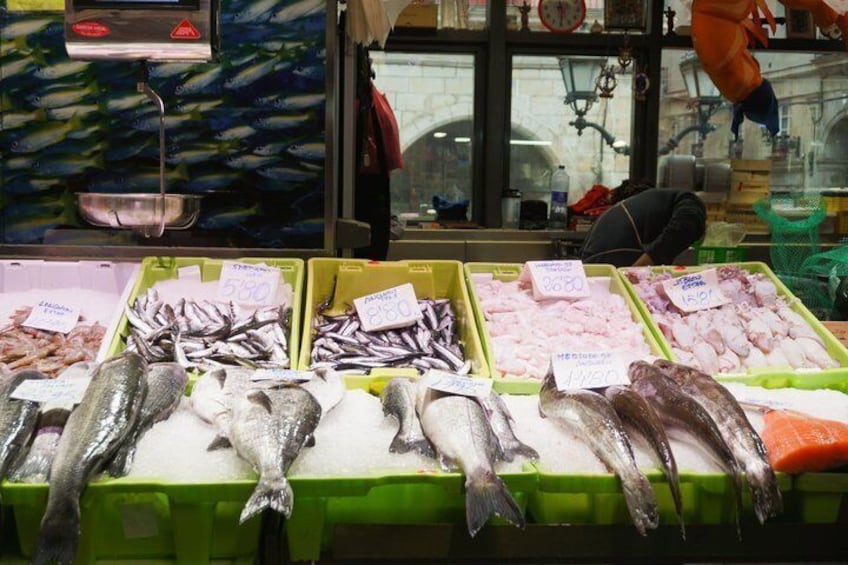 A fish market with various types of fish displayed in green trays. 4