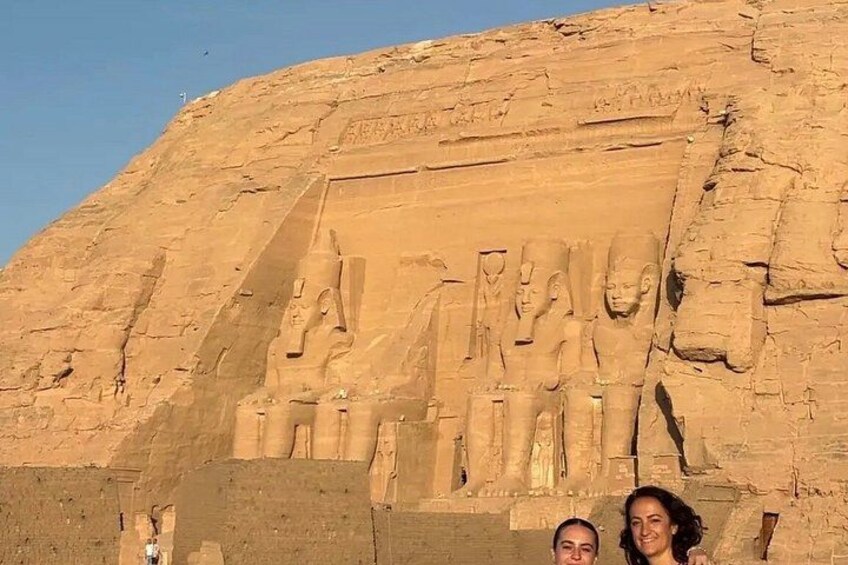 A large rock face with ancient carvings of figures and hieroglyphs. 4
