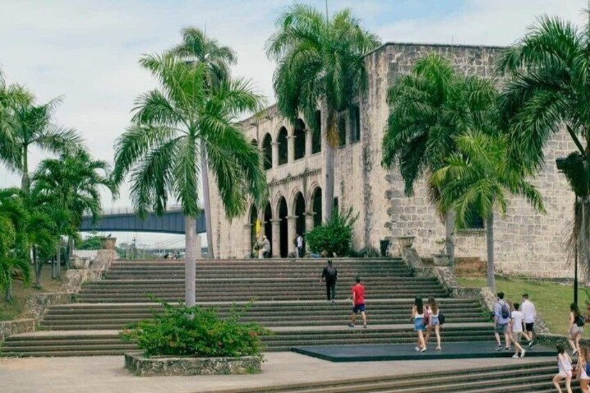 A historic building with arched windows and palm trees. 2