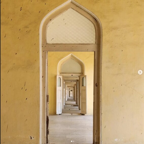 A corridor with arched doorways leading to a series of rooms. 2