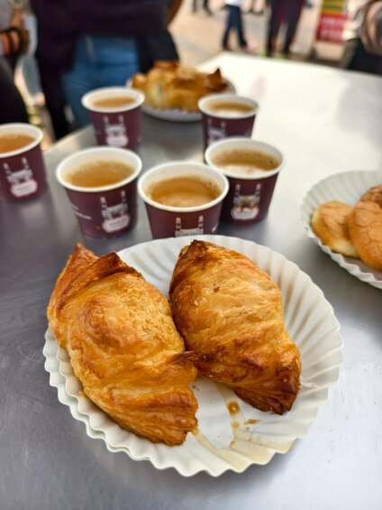 A table with croissants and coffee cups. 3