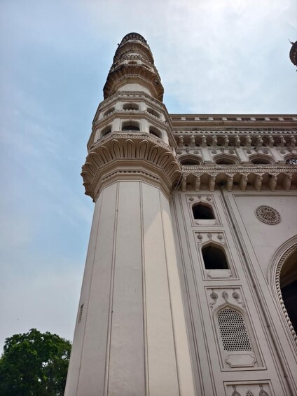 A tall, ornate minaret with intricate carvings and a large arched doorway. 4