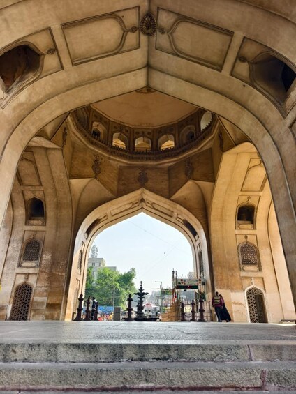 An arched architectural structure with intricate designs and a view of the cityscape in the background. 5