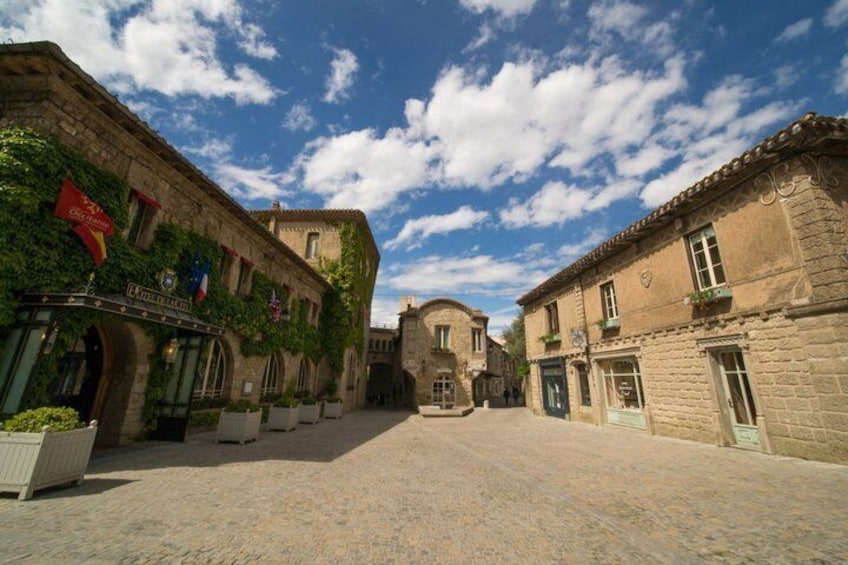 A cobblestone street with historic buildings, flags, and a clear sky. 3