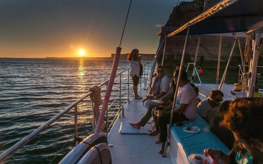 A sunset on a boat with people dining and enjoying the view. 5