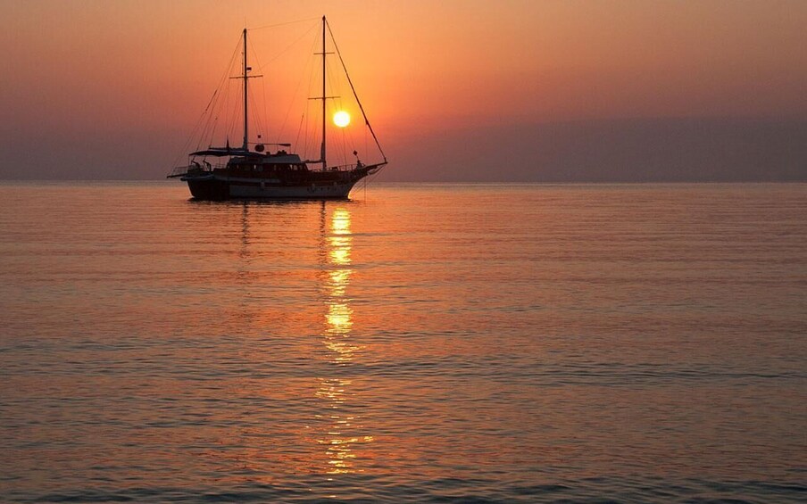 A sailboat on calm water during sunset. 3