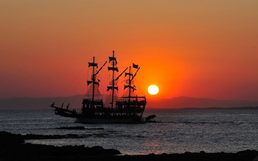 A ship silhouetted against a sunset with the sun low on the horizon. 5
