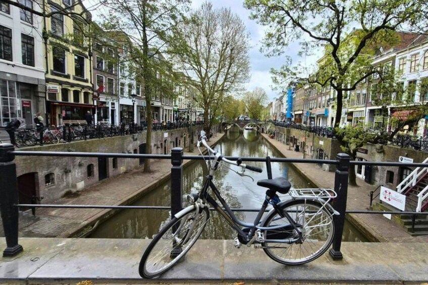 A canal with a bicycle parked on a stone bridge. 2
