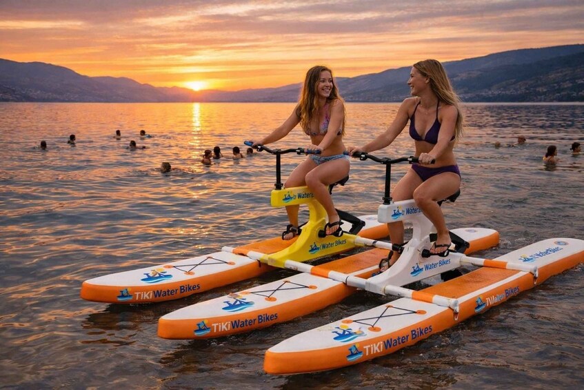 Two people riding water bikes on a lake at sunset. 4