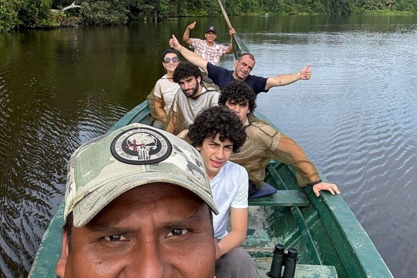 A group of people in a green boat on a calm river surrounded by greenery. 5