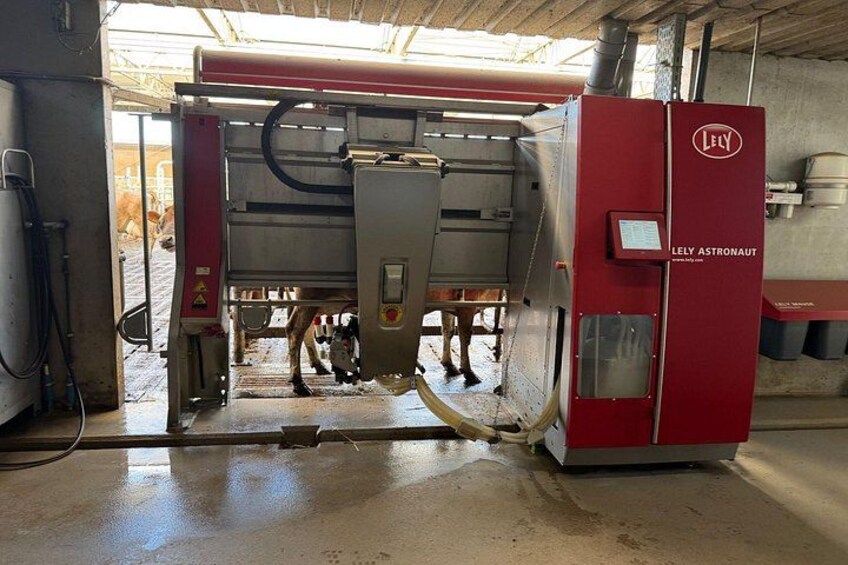 A red industrial machine with a hopper and control panel, located in an indoor setting with a concrete floor. 3