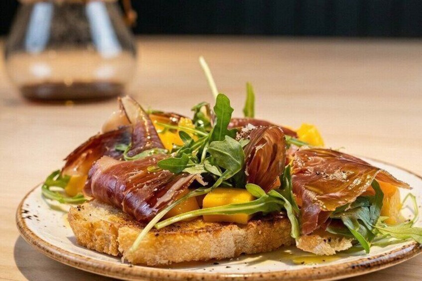 A plate of food with bread, greens, and meat. 1