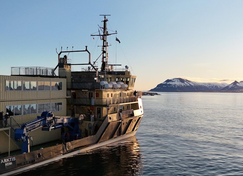 A ship named 'ARKTIS KEMI' docked at a port with a mountainous landscape in the background. 5