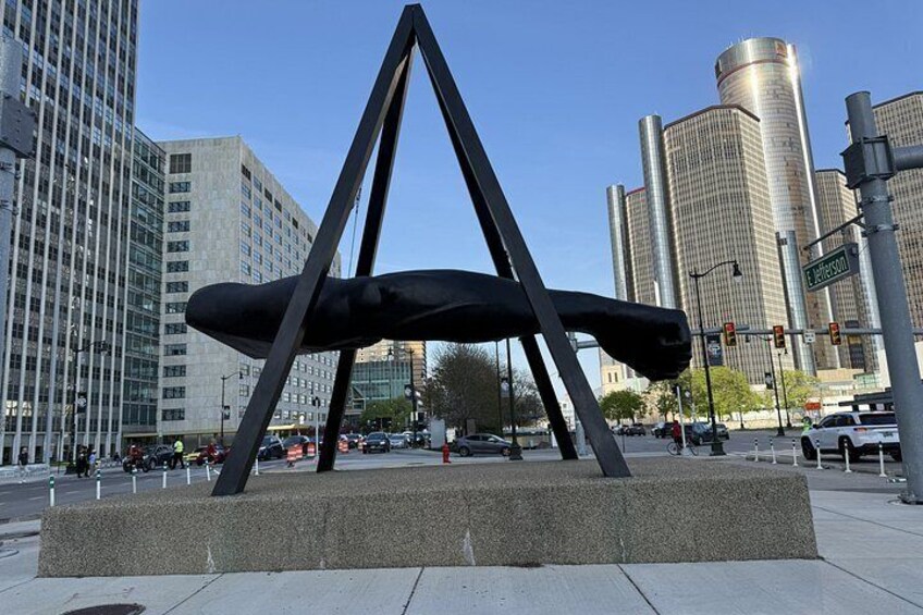 A modern sculpture in an urban setting with tall buildings in the background. 4