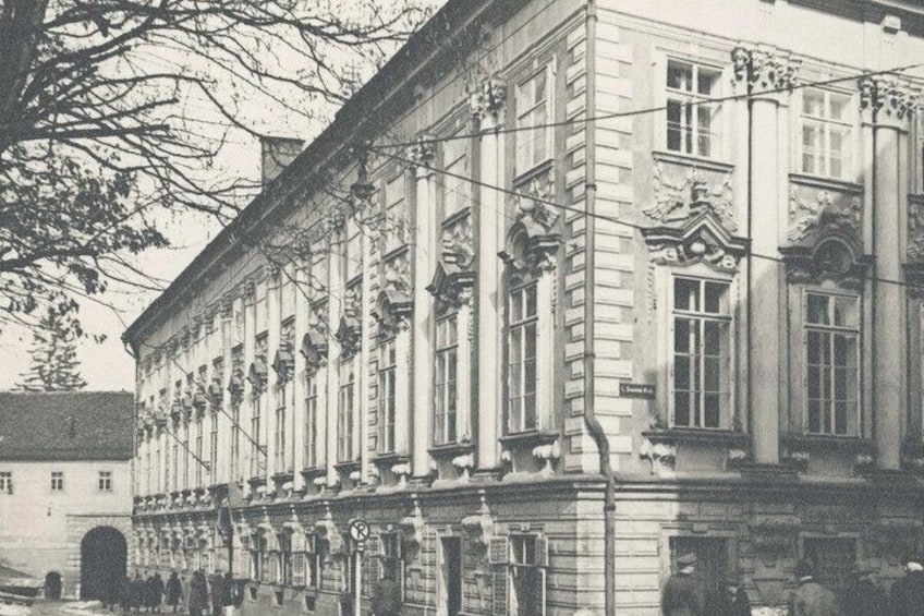 A historic building with classical architecture, featuring columns, detailed stonework, and arched windows. 1