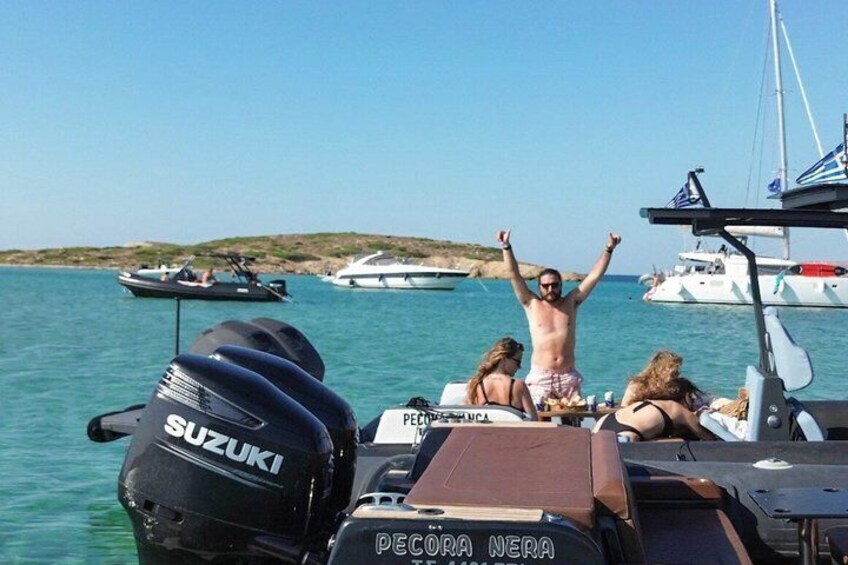 A boat with a Suzuki outboard motor, a person standing with arms raised, and another person seated at a table. 5