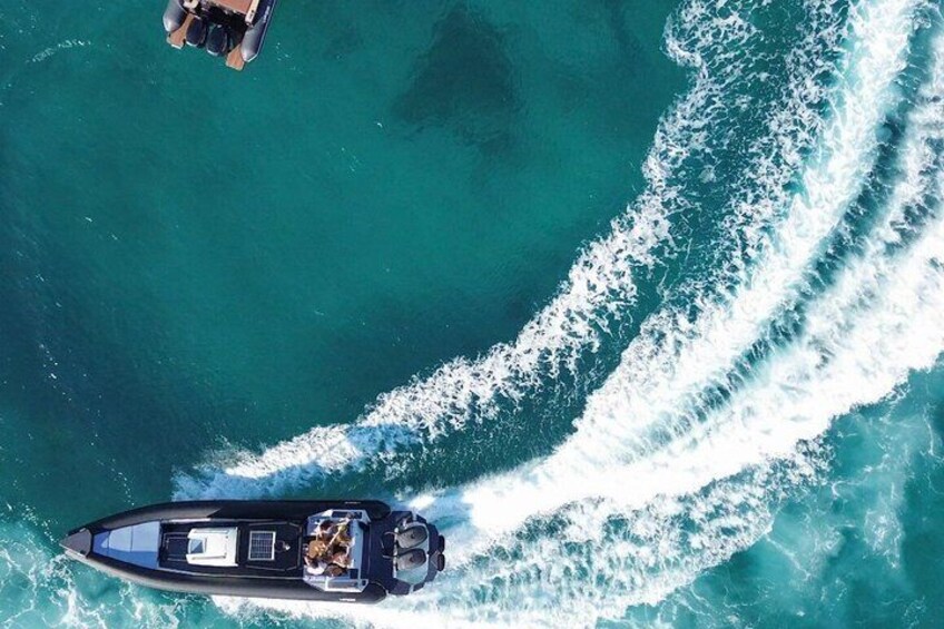 A speedboat creating a wake in turquoise water. 2
