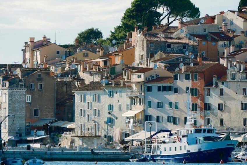 A coastal town with colorful buildings, a dock with boats, and a clear sky. 3