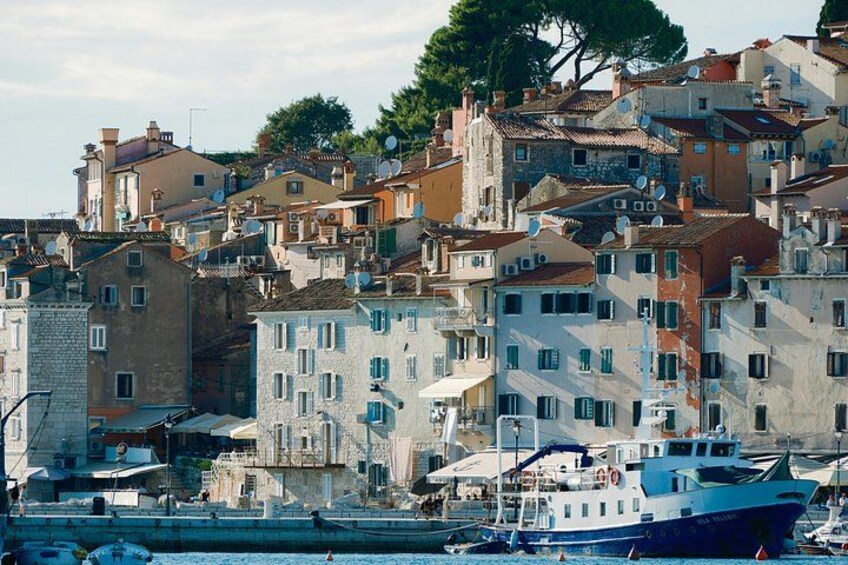 A coastal town with colorful buildings, a dock with boats, and a clear sky. 2