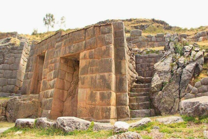 Ancient stone ruins with a large doorway and steps leading up to it. 3