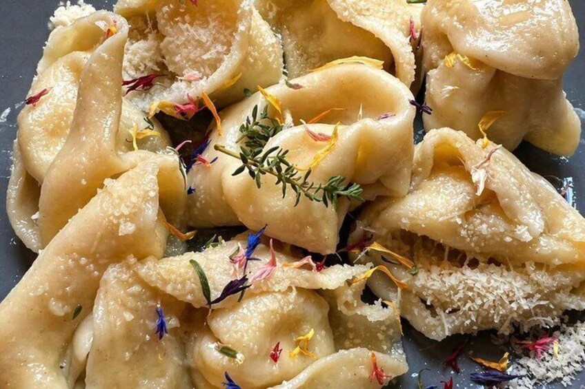 Ravioli with a creamy sauce, garnished with herbs and edible flowers. 3