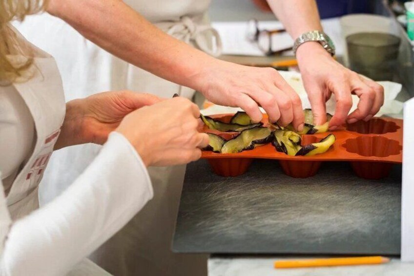 Hands placing sliced vegetables into a muffin tin. 2