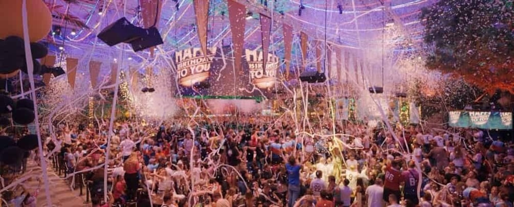 A crowded indoor event with confetti and streamers. 3