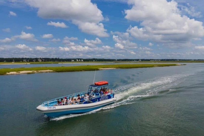 A speedboat with passengers on a calm river. 4
